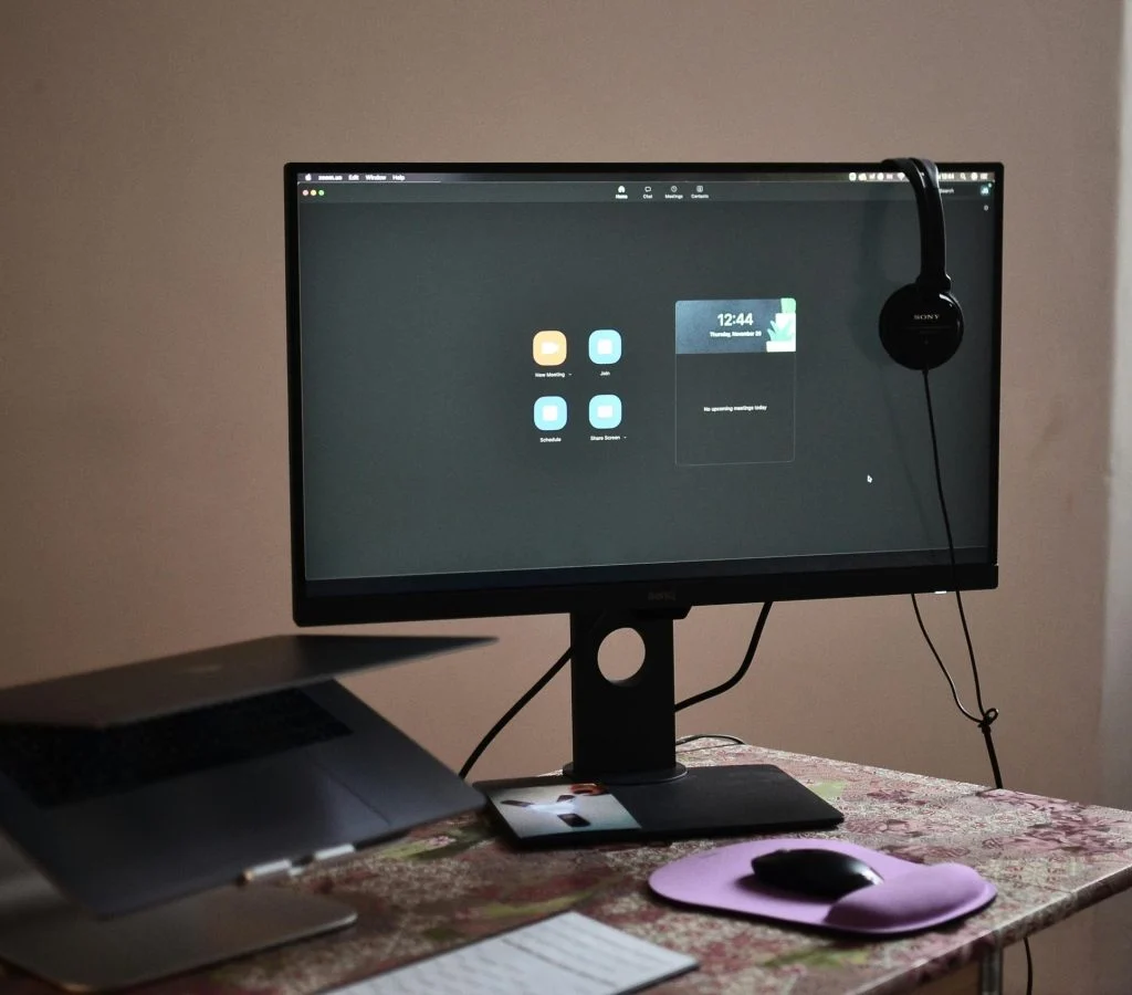 Photo of a laptop and desktop computer side by side in a workspace setup