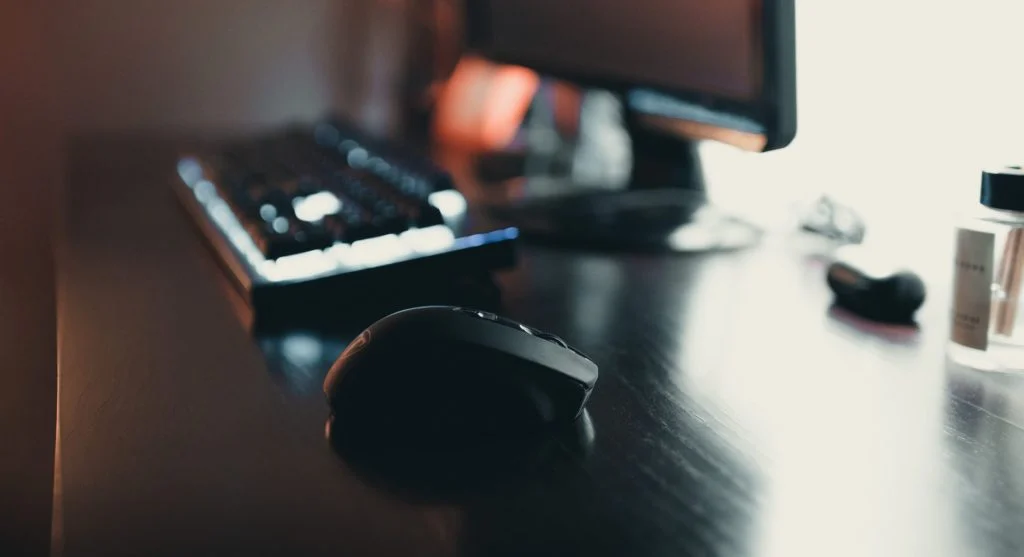 Person buying a desktop PC with monitor, keyboard, and mouse on a desk