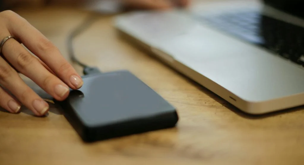 A person holding a laptop charger with a puzzled expression